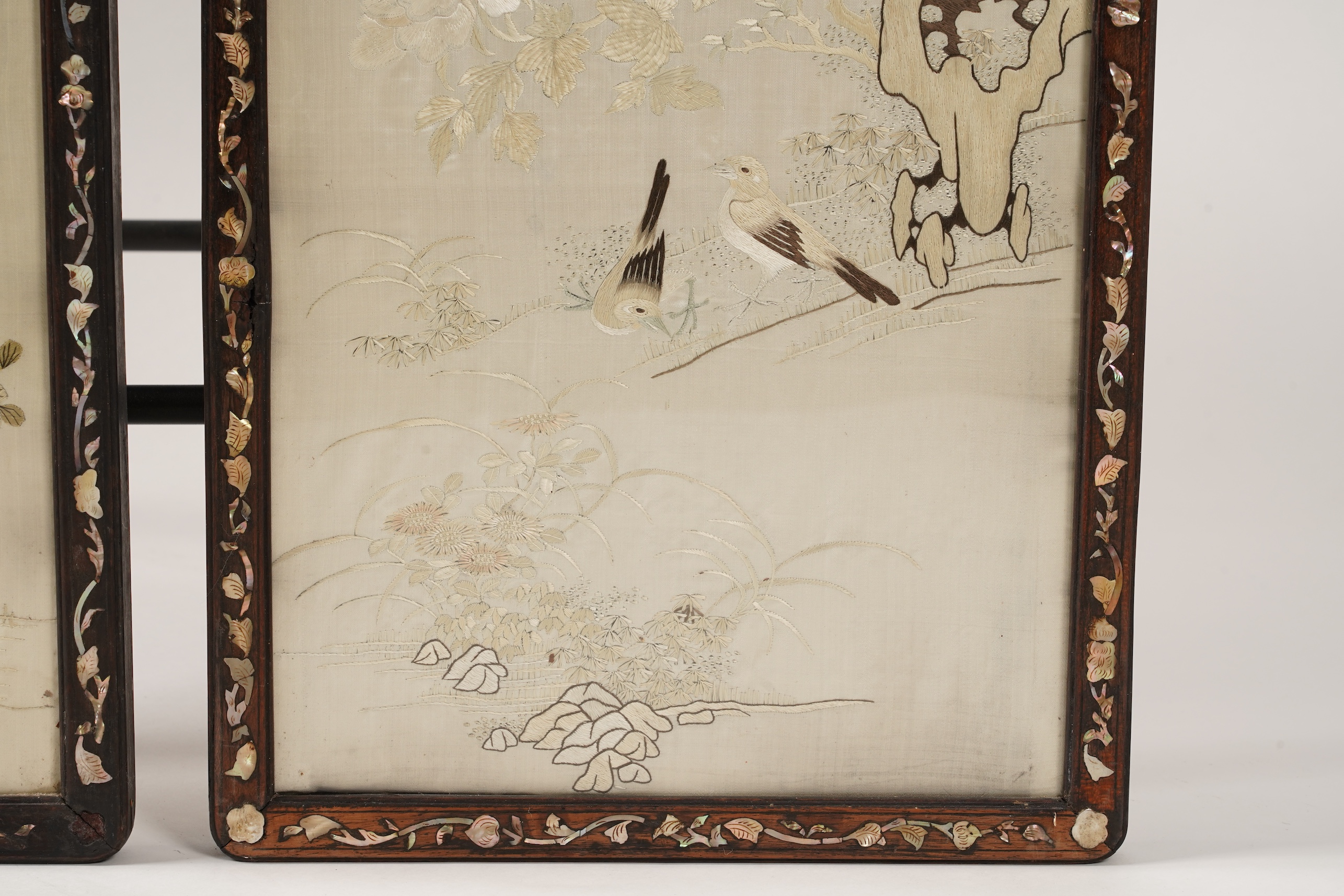 A pair of Chinese embroidered silk ‘bird’ panels, in mother-of-pearl inlaid hongmu frames, late 19th/early 20th century